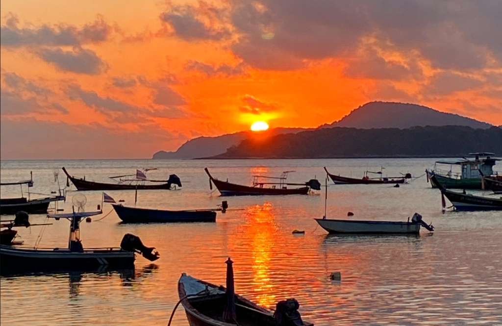 💰 Investing Guides | Phuket vs Bali vs Vietnam – Where to Invest? Traditional longtail boats at sunrise on Rawai Beach in Phuket, showcasing the tranquil lifestyle and investment appeal of the region.