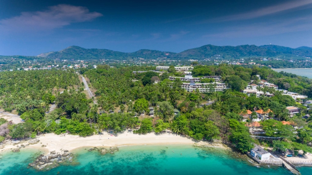 Aerial view of a tropical beach and nearby hillside developments in Phuket, Thailand