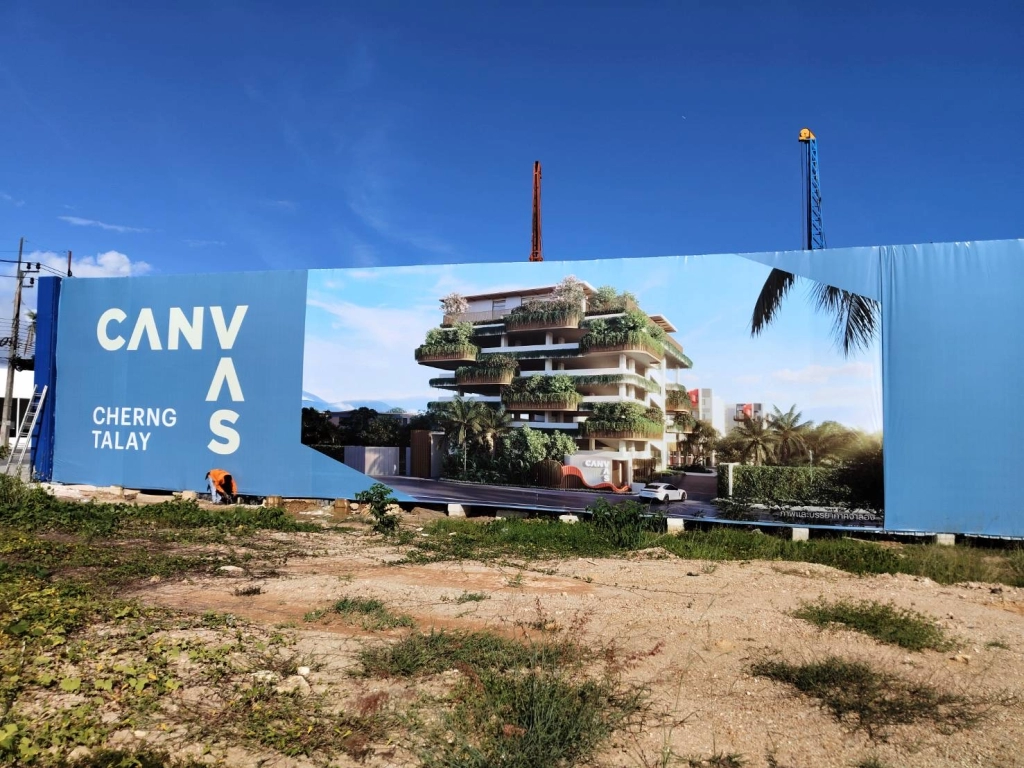 Entrance billboard of Canvas Cherng Talay off-plan project in Phuket, with construction site and developer branding