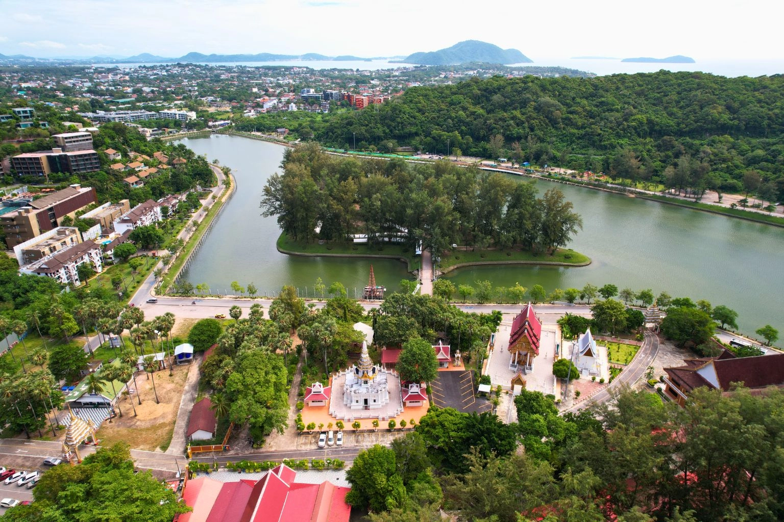 Aerial view of Nai Harn Lake in Phuket South, surrounded by greenery, temples, and low-rise developments — a popular area for investing in Rawai & Nai Harn.