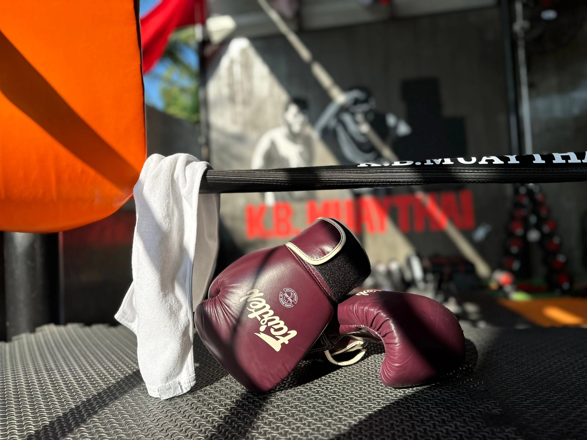 Muay Thai boxing gloves and towel on a training ring at K.B. Muay Thai gym in Rawai — showcasing the active lifestyle that draws investors to Nai Harn.