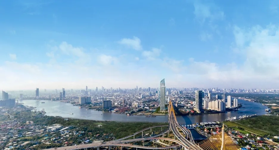 A panoramic view of Bangkok's skyline with the Bhumibol Bridge spanning the Chao Phraya River, highlighting the city's growing real estate developments.