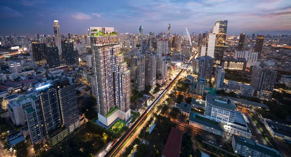 Aerial view of central Bangkok’s skyline with illuminated condo towers and vibrant city lights, showcasing prime investment neighborhoods.