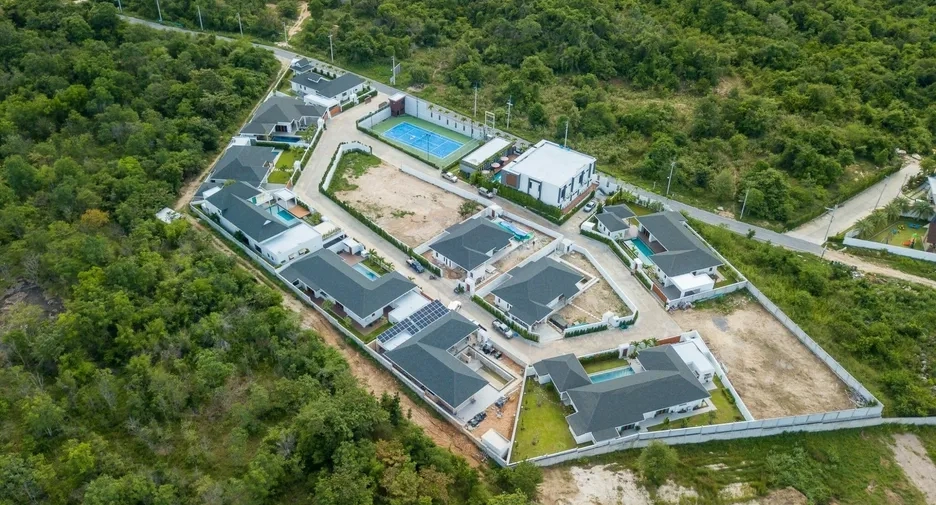 Aerial view of a residential development with multiple homes, ideal for real property investment and building wealth through real estate.