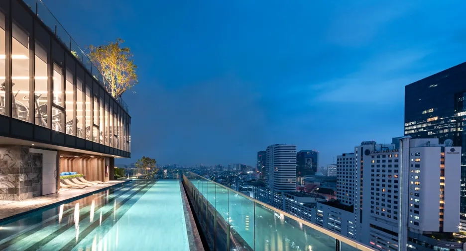 Luxury rooftop pool overlooking city skyline in Southeast Asia property development.