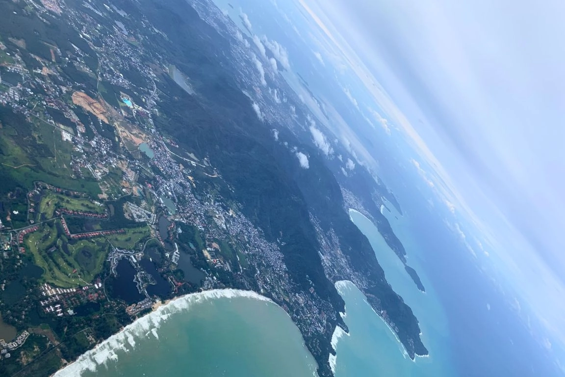 Aerial view of Phuket coastline near Bangtao Beach showing residential areas and shoreline relevant to Phuket Property Investment.