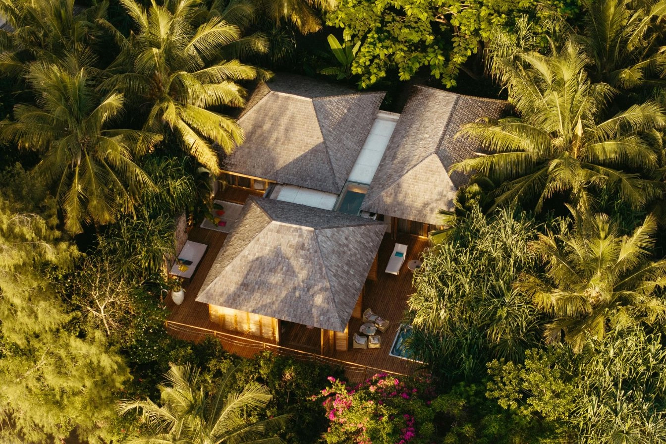 Aerial view of a luxury Bali villa surrounded by tropical trees illustrating overseas property investment and currency risk