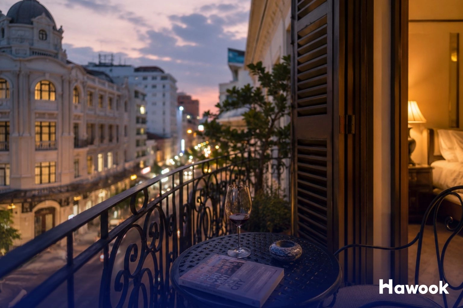 Luxury hotel balcony overlooking a historic city district in Southeast Asia at sunset, highlighting tourism and real estate growth.