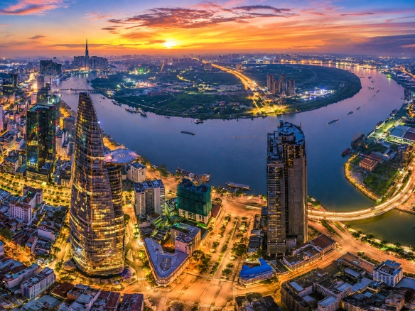 Aerial sunset view of Ho Chi Minh City skyline and Saigon River, illustrating Vietnam's Housing Law 2023 and Land Law 2024 foreign buyer property market